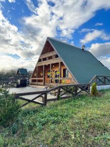 eine große Holzhütte mit grünem Dach in der Unterkunft Vikendica u blizini Beograda - A Frame in Veliki Borak