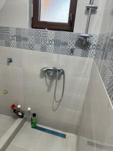 eine Dusche im Bad mit Fliesenboden in der Unterkunft Vikendica u blizini Beograda - A Frame in Veliki Borak