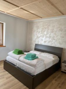 una camera da letto con un letto con cuscini verdi di Old B&B a Cesiomaggiore