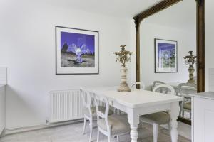 a white dining room with a white table and chairs at Pass the Keys Bright Cosy Cottage in Esher, West End in Esher