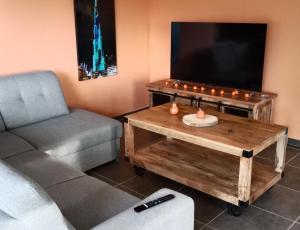 a living room with a couch and a tv and a coffee table at Le Relax in Corgnac-sur-lʼIsle