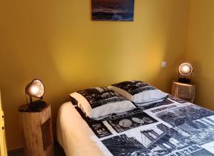 a bedroom with a bed and two lamps on tables at Le Relax in Corgnac-sur-lʼIsle