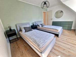 - une chambre avec 2 lits et un miroir dans l'établissement Bis 4 Pers. 0,3 km zur City von Wuppertal – neuwertige Wohnung, à Wuppertal