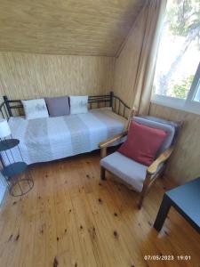 um quarto com uma cama, uma cadeira e uma janela em Σοφίτα Μαρτά em Kalamos