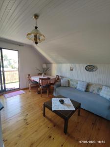 uma sala de estar com um sofá azul e uma mesa em Σοφίτα Μαρτά em Kalamos