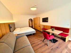 Habitación de hotel con sofá y cama en Hotel Tanja-Sonnenhof en Laces