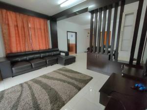 a living room with a black leather couch and a rug at Crown imperial in Brinchang