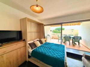 勒格罗-迪鲁瓦Studio CLIM Terrasse Privée - Proche de la Plage的一间卧室，配有一张床和一张桌子和椅子