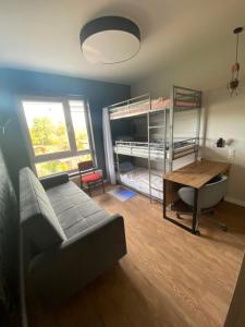 a living room with a couch and a desk and bunk beds at RADLIŃSKA FOLWARK in Kielce