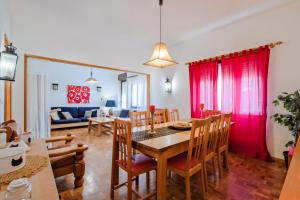 een eetkamer en woonkamer met een tafel en stoelen bij Villa Magoito in Sintra