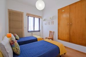 シントラにあるVilla Magoitoのベッドルーム1室(青いベッド2台、木製キャビネット付)