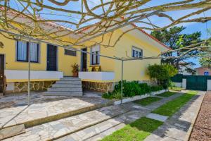 een geel huis met een trap en een tuin bij Villa Magoito in Sintra