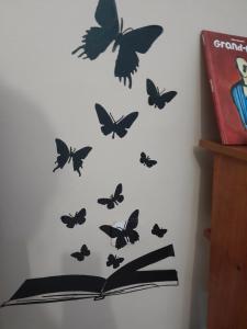 un libro abierto con mariposas en una pared en Disfruta de un barrio tranquilo, en Alcalá de Guadaira