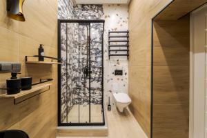 a bathroom with a toilet and a glass shower at InshiApartments on Vahylevycha Str in Lviv