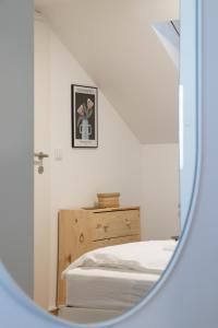 um quarto com uma cama e um espelho em City Apartments Dornbirn Gemütliches Apartment im Stadtzentrum Dornbirn, Kopenhagen 5 em Dornbirn