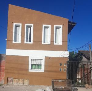 um edifício com janelas brancas do lado em Alojamiento walter em Ezeiza
