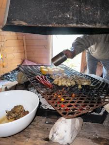 a man is cooking food on a grill at 3ART recreation in Tromsø
