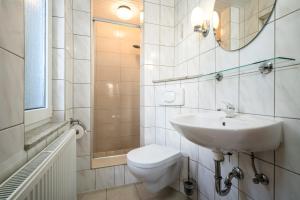 a white bathroom with a sink and a toilet at Ferienhaus Haus am See mit Wassergrundstück in Lärz