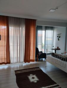 - un salon avec un lit bébé et de grandes fenêtres dans l'établissement TOSKANA OTEL RESTORANT, à Şarköy
