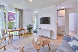 una sala de estar con un sofá y una mesa en Lüttjeod Apartmentvilla 04, en Langeoog