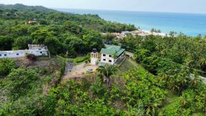 an aerial view of a house on a hill next to the ocean at HOSTAL MIRADOR TAYRONA in Santa Marta