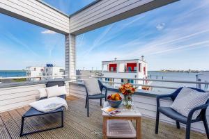 a balcony with chairs and a view of the ocean at Ferienhaus Nordlicht Olpenitz in Olpenitz
