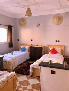 sypialnia z 2 łóżkami i blatem w obiekcie Natural Surf House w mieście Tamraght Ouzdar