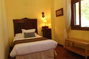 1 dormitorio con cama y ventana en Casa Rural El Gaiter, en Aguaviva