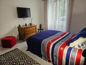 sypialnia z łóżkiem i telewizorem na ścianie w obiekcie Appartement T2 bis à morbier w mieście Morbier