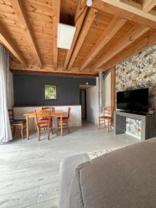 - un salon avec une table, des chaises et une télévision dans l'établissement La Souste appartement avec jardin privatif, à La Fare-en-Champsaur