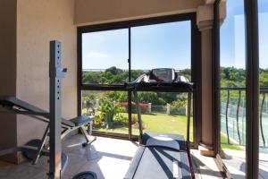 a room with a gym with a large window at Stay@Tuscany - 3 Bedroom Luxury Holiday Home in Mossel Bay