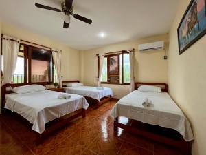 a bedroom with two beds and a ceiling fan at HOSTAL MIRADOR TAYRONA in Santa Marta