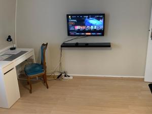 a room with a desk and a tv on a wall at chambre cosy in Annappes