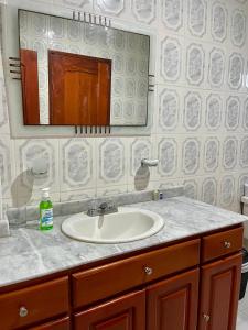 a bathroom with a sink and a mirror at HOSTAL MIRADOR TAYRONA in Santa Marta