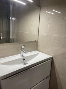 ein Badezimmer mit einem weißen Waschbecken und einem Spiegel in der Unterkunft Sole Mia, appt 2/4pers au cœur de Bormes in Bormes-les-Mimosas