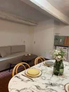 ein Wohnzimmer mit einem Tisch, Stühlen und einem Sofa in der Unterkunft Sole Mia, appt 2/4pers au cœur de Bormes in Bormes-les-Mimosas