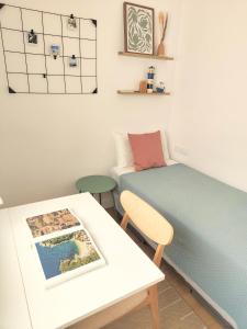 Cette petite chambre comprend un lit et une table avec une photo. dans l'établissement Roda Beach Apartment, à Roda de Bará