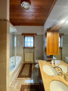 a bathroom with two sinks and a bath tub at Villa La Collina in Giais +16 photos
