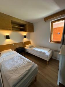 - une chambre avec 2 lits et une fenêtre dans l'établissement Apartment Paradiski 309, à La Plagne Tarentaise