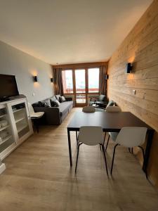 - un salon avec une table et un canapé dans l'établissement Apartment Paradiski 309, à La Plagne Tarentaise