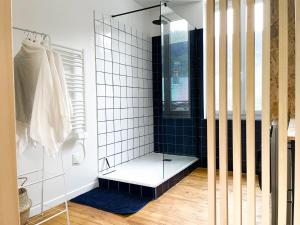 a shower with a glass door in a bathroom at Appartement Rose velours in Le Mont-Dore