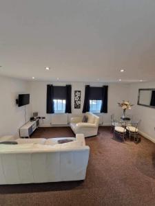 een woonkamer met twee witte banken en een tafel bij 5 Laurel Court in Ulverston