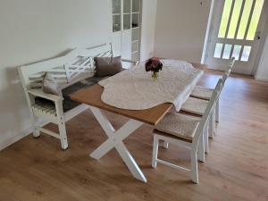 a dining room table with two chairs and a vase of flowers at Alter Bahnhof Blickweiler in Blieskastel