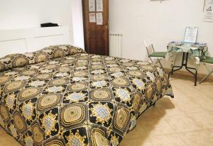 a bed in a room with a table and a chair at La Perla B & B in Ciampino