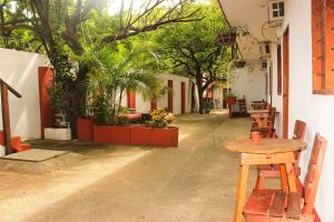 un tavolo e sedie in un cortile alberato di Sierraventura Hostel a Taganga