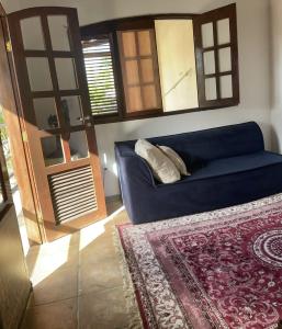 uma sala de estar com um sofá azul e um tapete em Flat ACM em Natal