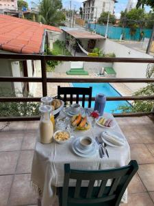 a table with breakfast food on a balcony with a view at Flat ACM in Natal