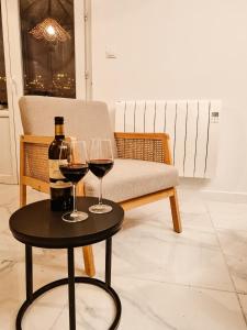 - deux verres de vin sur une table à côté d'un canapé dans l'établissement 5e Ciel - [sans ascenseur - devant gare / centre-ville], à Tulle