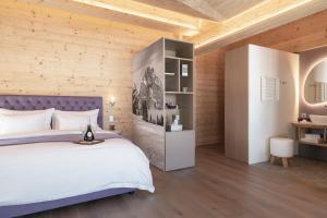 - une chambre avec un grand lit et un mur en bois dans l'établissement Caschu Alp Boutique Design Hotel Stoos - adults only, à Stoos