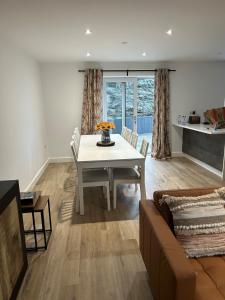 a living room with a white table and a couch at Garreg Fawr Trearddur Bay - Ty Oren in Trearddur